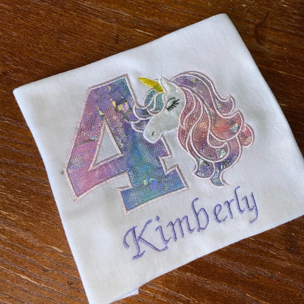 Girls personalize unicorn birthday shirts.